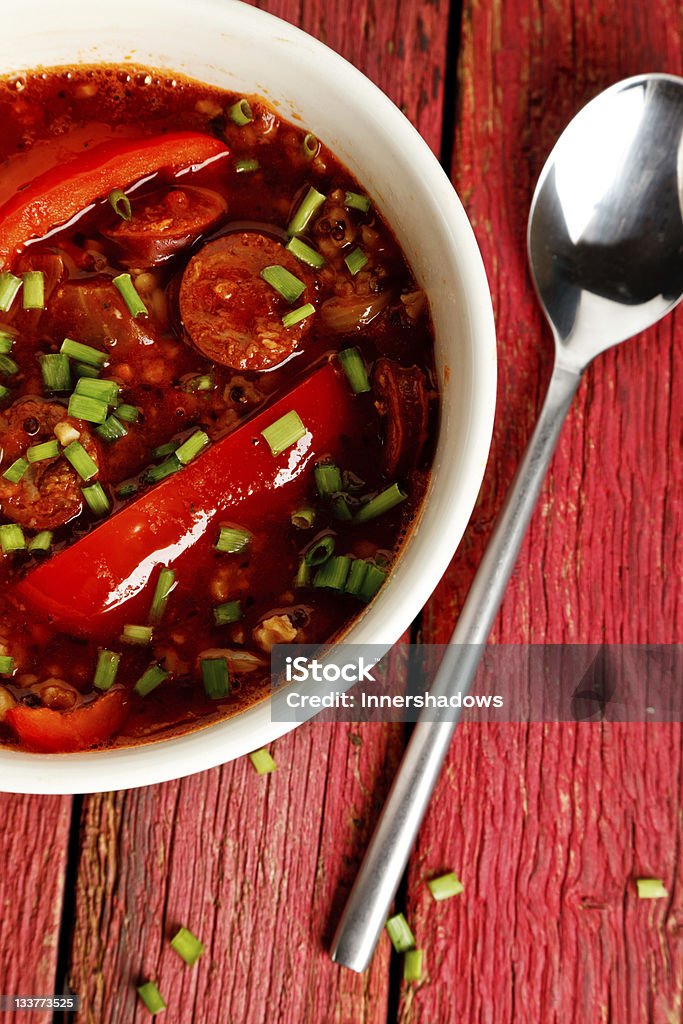 Chorizo stew Chorizo stew on a red wooden background Chorizo Stock Photo