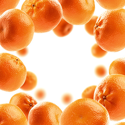 Whole oranges levitate on a white background.