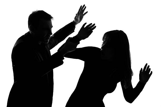Silhouettes of a man and a woman during an altercation stock photo