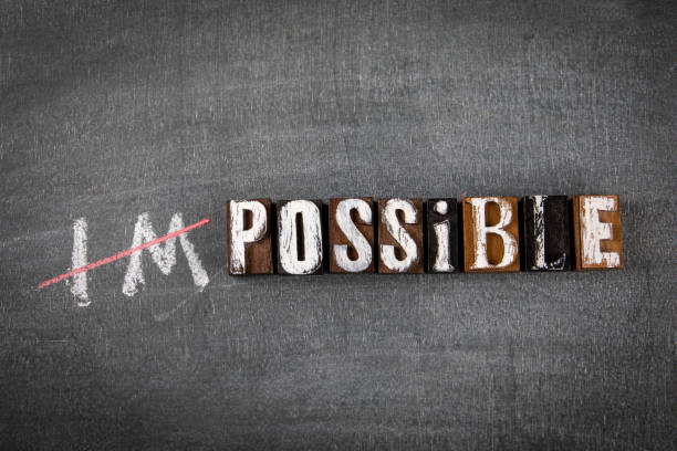 istock Impossible and Possible Concept. Wooden alphabet letters on a black chalk board 1337743430