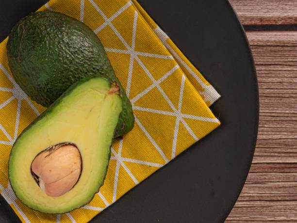 istock avocado on wood table top view image for food concept. 1337744417