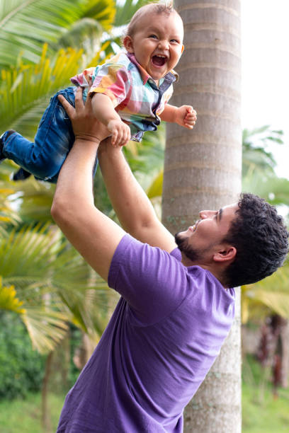 istock Father holding his son high.baby smiling with her father 1337746971