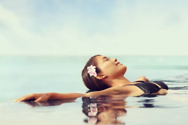 istock Luxury resort woman relaxing in infinity swim pool 1337748473
