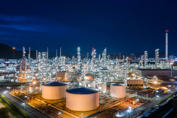 instalaciones de fabricación y almacenamiento de productos de refinerías de petróleo y gas para ventas y exportación envío internacional transporte asustado vista aérea de mar abierto por la noche sobre iluminación con fondo de cielo azul - buque tanque petrolero fotografías e imágenes de stock