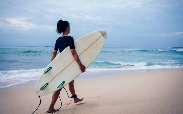 istock Surfer woman running with surfboard on the beach 1337753778