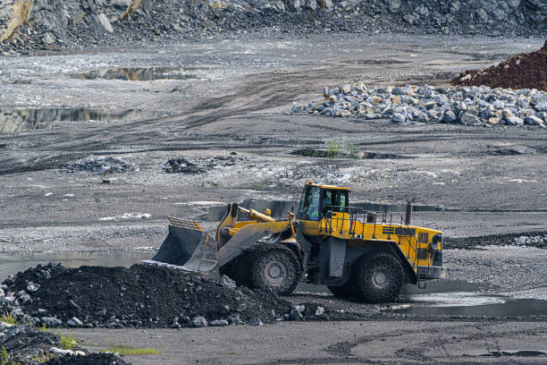 istock Front loader with large wheels and steel chains. Opencast mining quarry with machinery and mining equipment. Limestone mining for cement production. 1337754674