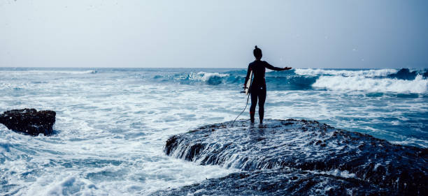 istock Woman surfer with surfboard going to surf on seaside 1337754981