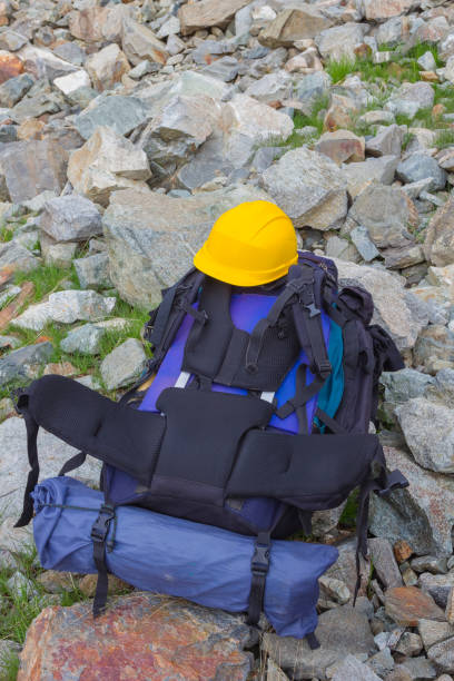 istock touristic backpack and yellow helmet on a stones 1337759888