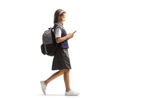istock Schoolgirl walking and typing on a smartphone 1337761447