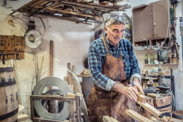 old-fashioned way of processing wood as aged carpenter holds tools to smooth the wooden surface. - carpentry toolbox craft product work tool imagens e fotografias de stock