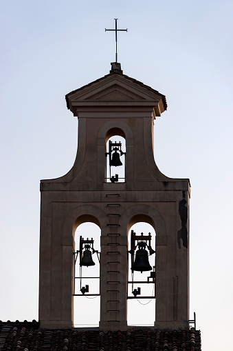 Bell tower of a chapel in Josselin in Brittany with a pigeon perched on the cross