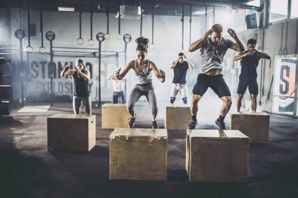 istock Athletic people exercising jumps on crates during gym training in a gym. 1337763619