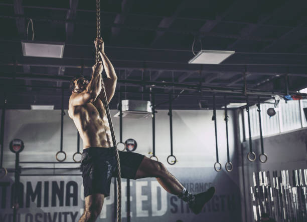 istock Young athletic man exercising strength on a rope in a gym. 1337764113