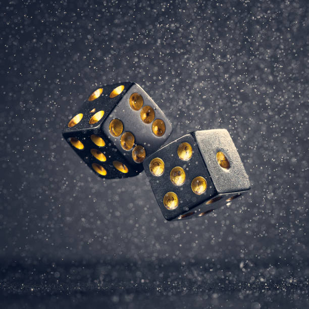 istock Two black dice are falling on a dark gray background. Photo with bokeh. 1337765499