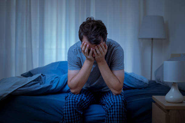 Man suffering depression and feeling negative emotions Depressed man at night feeling alone and useless sleeping stock pictures, royalty-free photos & images