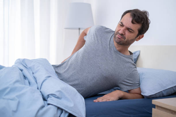 istock Man lying in bed and suffering from back pain 1337767844