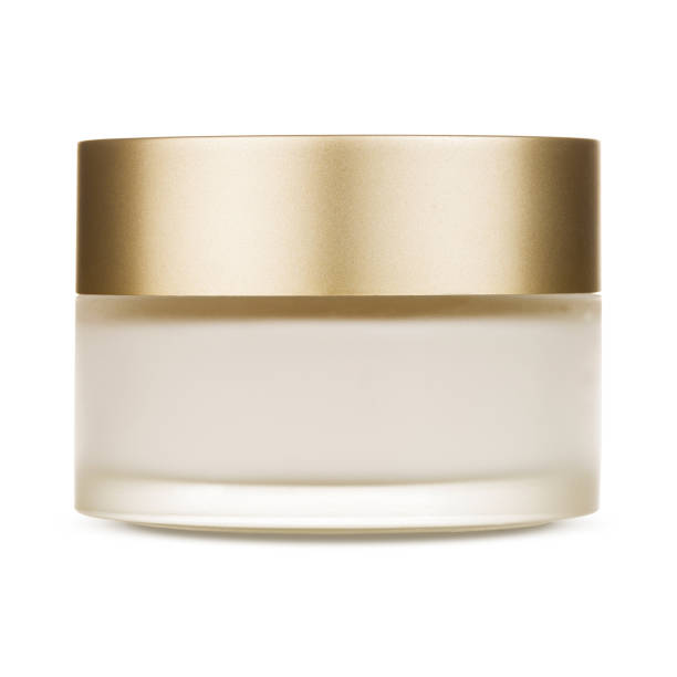 a round glass jar for cosmetics with a gold lid. - moisturizer cosmetics beauty treatment jar imagens e fotografias de stock