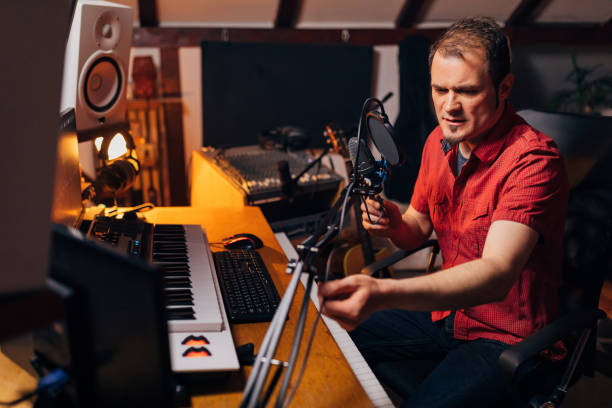 istock Podcaster adjusting his microphone, before he starts to record his music podcast 1337771076