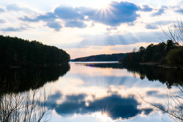 istock Scenic View Of Calm Lake At Sunset. River weather sun rays. Clouds. Mirror effect 1337773606