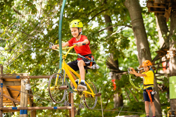 istock Adventure climbing high wire park - little boy on course in mountain helmet and safety equipment 1337774607