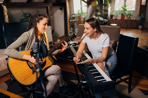 At the music and recording studio, female musicians spending the creative time while writing the song for their new album