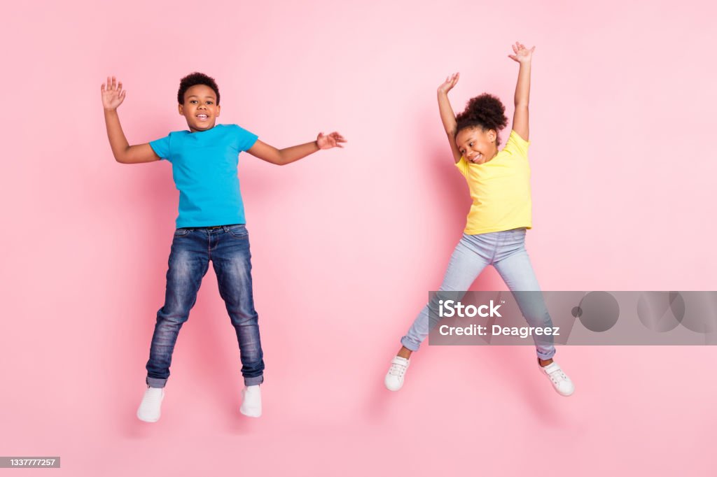 Full length body size view of two attractive cheerful kids jumping having fun isolated over pink pastel color background Full length body size view of two attractive cheerful kids jumping having fun isolated over pink pastel color background. Child Stock Photo