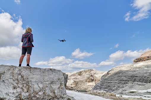 Images from Northern Italy - Passo Pordoi. Altitude 2950 meter.
Young woman flying with her drone in the Alps. Italian Dolomites
