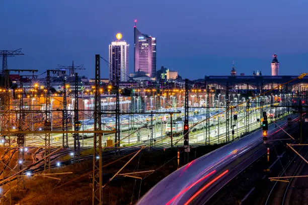 Long exposure with illuminated cityscape, skyscrapers, main station and incoming train.