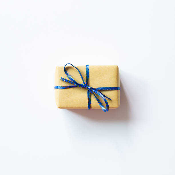 istock Yellow gift box with blue ribbon isolated on white background. top view, copy space 1337779973