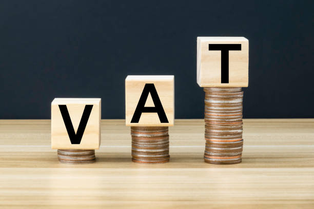 istock Word Vat with stacked coins on wood table. Vat Concept. 1337780053