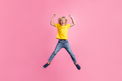 Full size photo of young boy happy positive smile jumper rejoice lucky success isolated over pink color background.