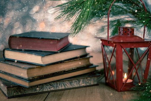 Christmas view with old books and lantern and copy space for christmas card.