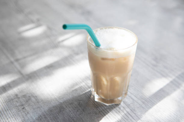 istock Glass of iced coffee with a drinking straw in dappled light 1337784698