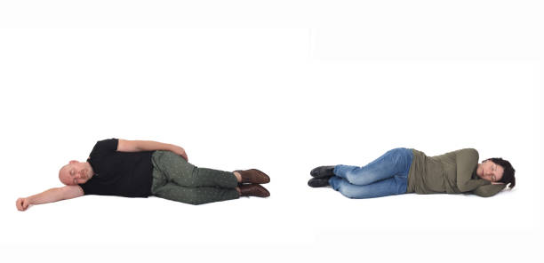 couple lying on the floor over white background couple lying on the floor over white background lying on side stock pictures, royalty-free photos & images