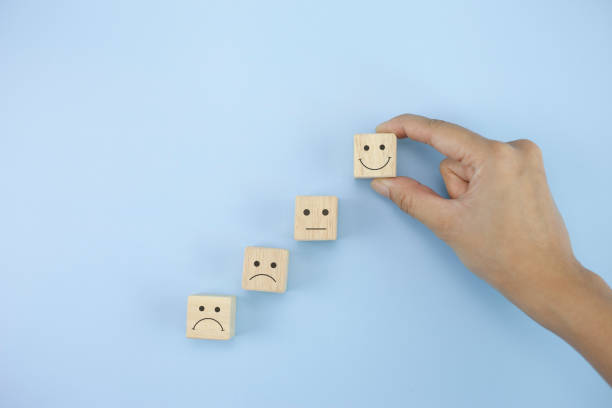 istock Closeup hand picked the happy face smile face icon symbol cube on blue background 1337786607