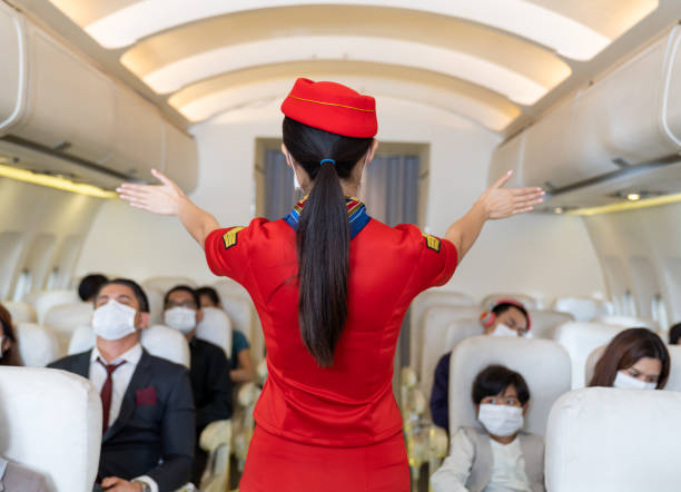 air stewardess explaining aeroplane safety to passengers - color image people air vehicle airplane imagens e fotografias de stock