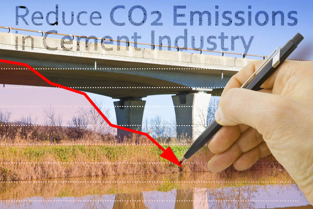 Reduce CO2 production in cement Industry and emissions in atmosphere - low-carbon cement production concept with elevated highway in concrete structure and hand drawing a descending graph about carbon dioxide emissions reducir la producción de co2 en la industria del cemento y las emisiones en la atmósfera: concepto de producción de cemento bajo en carbono con carretera elevada en estructura de hormigón y dibujo manual de un gráfico descendente sobre las emisiones d
