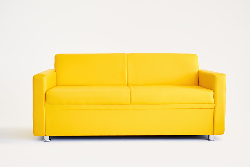 Comfortable bright yellow sofa on white background