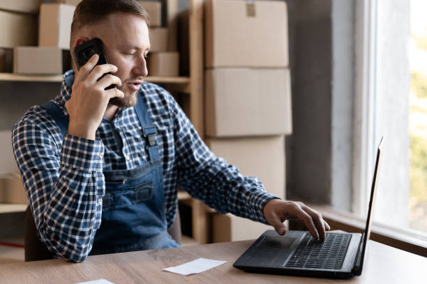 istock male salesman confirming orders from a customer by phone makes notes on her laptop. 1337794153