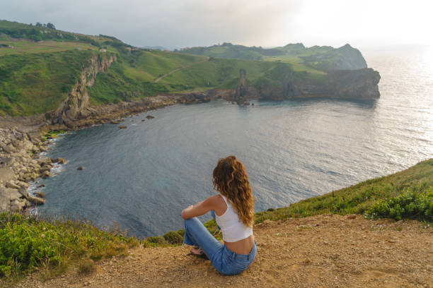 istock Panoramic view of unrecognizable woman sit in a cliff. 1337794244