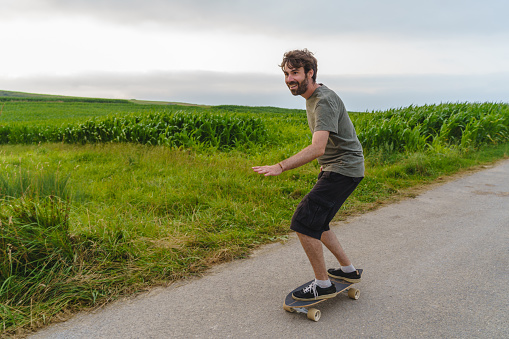 Horizontal view of skater boy in motion through a field.