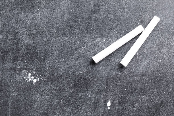 istock Pieces of white chalk on blackboard, flat lay. Space for text 1337794519