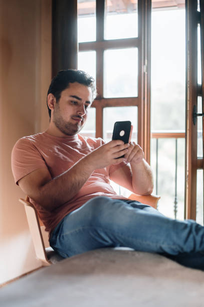 istock Young man at home using a smart phone 1337794615
