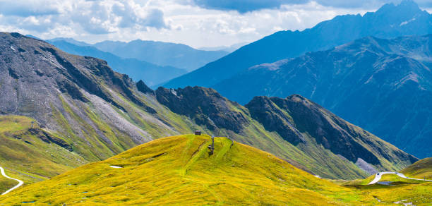 istock Mountains and green meadows on the blue and cloudy sky background. 1337799280