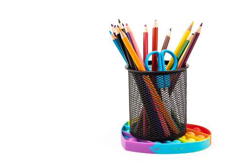 School colored pencils, children toy popit anti-stress on white background. Concept of the back to school.