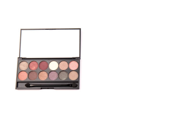 istock Eyeshadow palette. Black plastic case with twelve powder matte, glitter paint sample in purple, pink, brown, vanilla colors and brush. Top view makeup box isolated on white background 1337811698