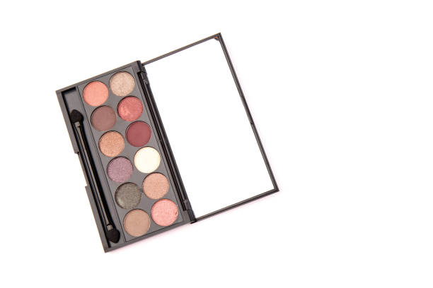 istock Eyeshadow palette. Black plastic case with twelve powder matte, glitter paint sample in purple, pink, brown, vanilla colors and brush. Top view makeup box isolated on white background 1337811706