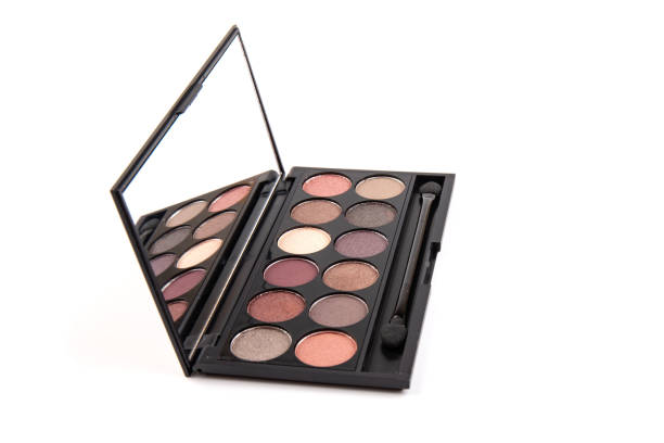 istock Eyeshadow palette. Black plastic case with twelve powder matte, glitter paint sample in purple, pink, brown, vanilla colors and brush. Top view makeup box isolated on white background 1337811707