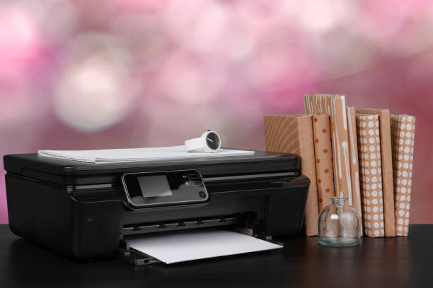 istock Stack of books and home printer against blurred background 1337812304