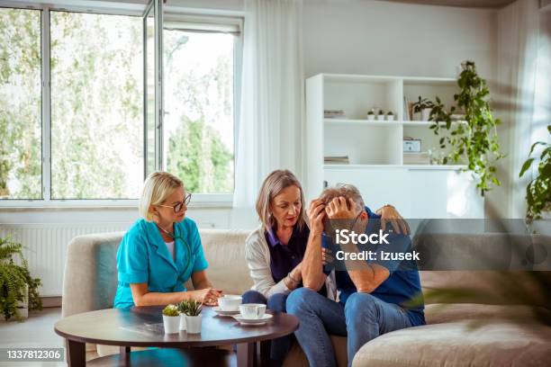Nurse Talking With Worried Senior Couple Stock Photo - Download Image Now - Head In Hands, Waiting Room, Hospital